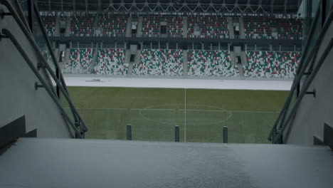 Empty-outdoor-football-soccer-stadium-field-covered-with-snow-in-winter,-light-snowfall.-Shot-with-2x-anamorphic-lens